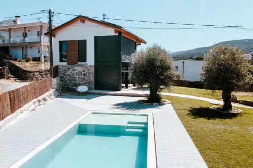 a swimming pool in front of a house at Refugio das Poldras-Villa 63 in Mondim de Basto