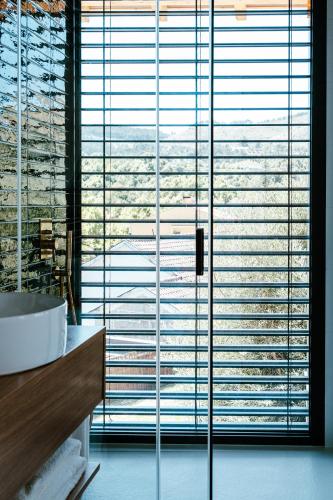 a bathroom with a large window with a tub at Refugio das Poldras-Villa 63 in Mondim de Basto