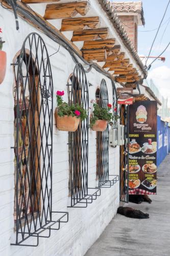 a building with wrought iron gates and potted plants at Hotel Boutique Casa de Hacienda Su Merced in Puembo