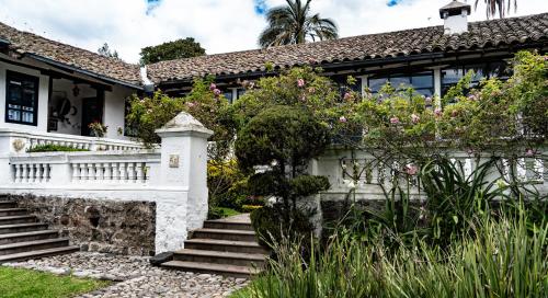 an old house with a garden and stairs at Hotel Boutique Casa de Hacienda Su Merced in Puembo
