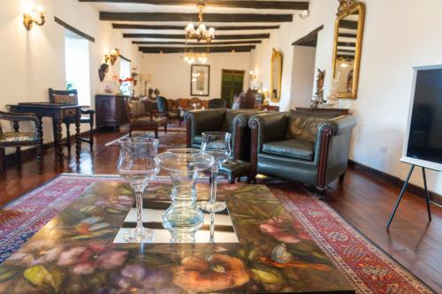 a living room with wine glasses on a table at Hotel Boutique Casa de Hacienda Su Merced in Puembo