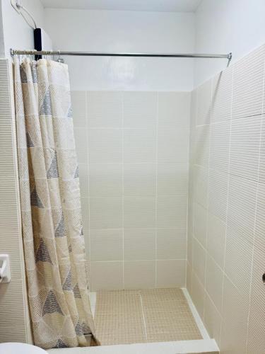 a shower with a shower curtain in a bathroom at Mesavirre Garden Residences - Skybox Living in Bacolod