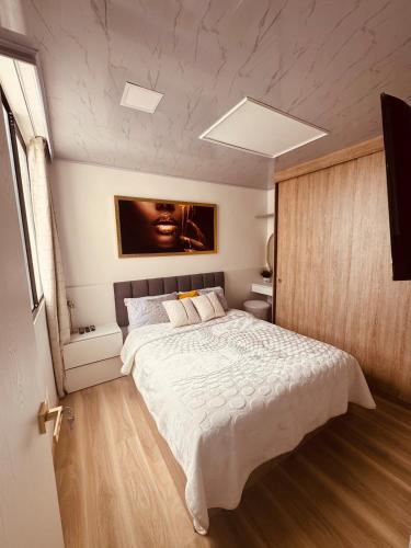 a bedroom with a large white bed in a room at Top views, airport, Salitre, American embassy, parking in Bogotá
