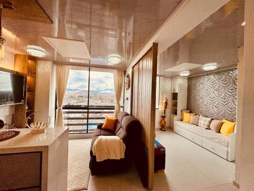 a living room with a couch and a large window at Top views, airport, Salitre, American embassy, parking in Bogotá