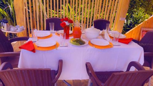 a white table with food and flowers on it at Lake District Homestay in Rubirizi