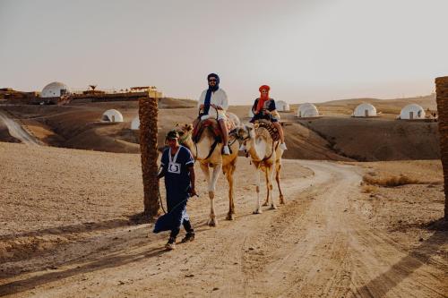 three people riding on horses on a dirt road at The Orion Dome in El Karia