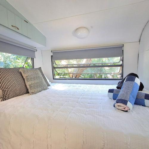a bedroom with a large bed and a window at Vintage Coral Blue in Nelly Bay