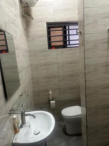 a bathroom with a sink and a toilet and a window at Jalloh little paradise in Madina
