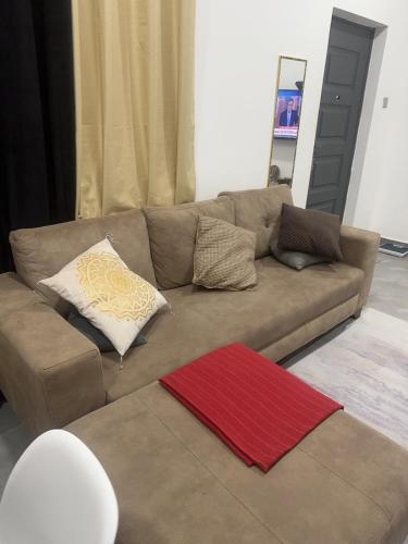 a brown couch in a living room with a red rug at Jalloh little paradise in Madina