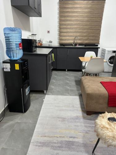 a kitchen with black cabinets and a table and a couch at Jalloh little paradise in Madina