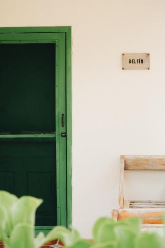 a green door with a sign that reads deficit at Hotel Cielo y Selva in Punta Allen