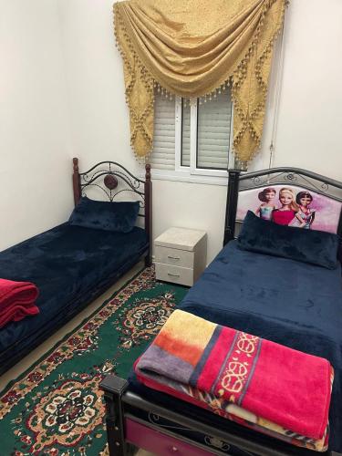 a bedroom with two beds and a window at Bel Appartement à louer à Fès in Fès