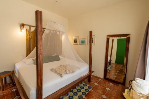 a bedroom with a bed with a canopy and a mirror at Hotel Cielo y Selva in Punta Allen