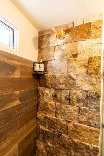 a stone wall in a bathroom with two candles at Hotel Cielo y Selva in Punta Allen