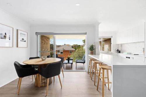 a kitchen and dining room with a table and chairs at Seascape - Luxury Apartment Near Cronulla Beach in Cronulla