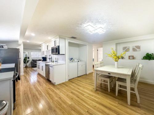 a kitchen with white cabinets and a table with flowers on it at Beautiful & Relaxing 2 kings in Tampa