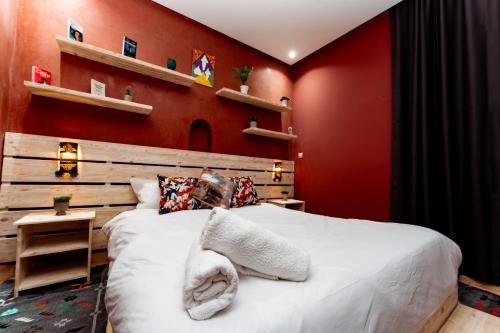a bedroom with a large bed with red walls at Nour Mogador in Ghazoua