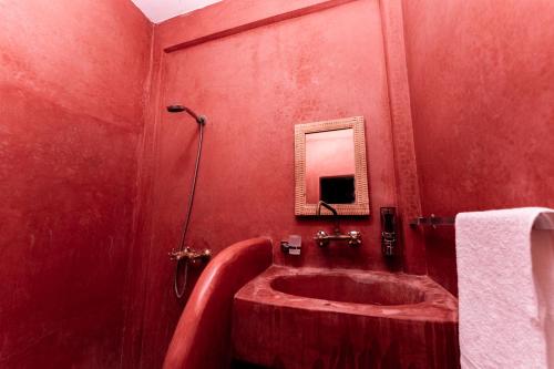 a red bathroom with a tub and a sink at Nour Mogador in Ghazoua