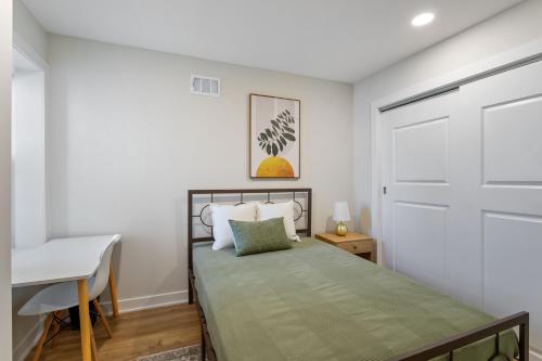フィラデルフィアにあるWelcome to The Lux Collective a Spacious 5-Bedroom House close to Stadiums, Universities, Center City & more!のベッドルーム1室(ベッド1台、デスク、ドア付)