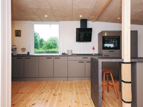 a kitchen with gray cabinets and a window and a counter at 6 person holiday home in Ebeltoft in Ebeltoft