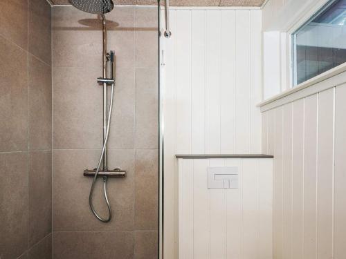 a shower with a glass door next to a white cabinet at 6 person holiday home in Ebeltoft in Ebeltoft