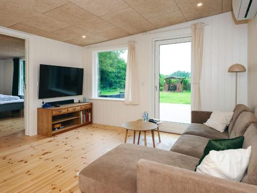 a living room with a couch and a flat screen tv at 6 person holiday home in Ebeltoft in Ebeltoft