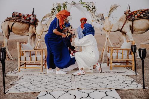 a group of three women standing in front of a tent at The Orion Dome in El Karia