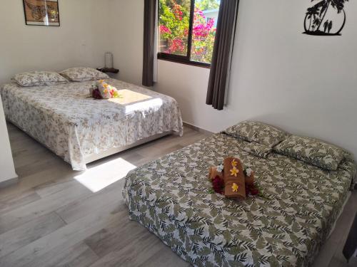 a bedroom with two beds and a couch with stuffed animals on it at Kahaia Lodge in Avatoru