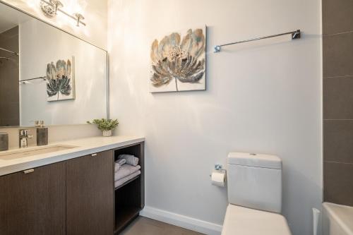a bathroom with a sink and a toilet and a mirror at Gorgeous 1 Bedroom Apt with Balcony in Yorkville in Toronto