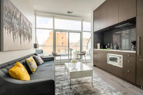 a living room with a couch and a table at Gorgeous 1 Bedroom Apt with Balcony in Yorkville in Toronto