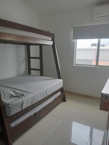 a bedroom with a bunk bed and a window at Precioso depa a 70 mts de playa in Manzanillo
