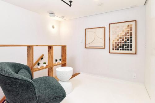a living room with a couch and a chair at KJ Hotel in Musashino