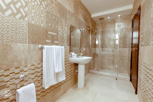 een badkamer met een wastafel en een douche bij Pyramids Oasis Hotel in Caïro