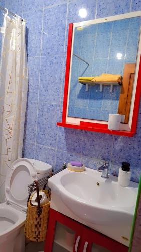 a bathroom with a sink and a mirror and a toilet at chambre familiale in Essaouira