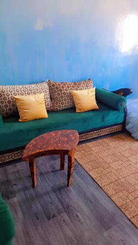 a living room with a green couch and a coffee table at chambre familiale in Essaouira