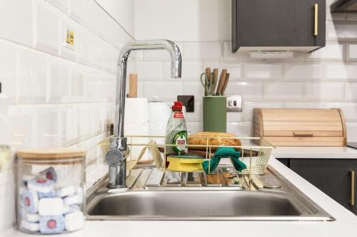 a kitchen sink with a dish drying rack in it at Comfortable Apartment In The Centre Of Preston in Preston