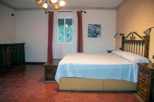 a bedroom with a bed and a dresser and a window at Casa rural Cavila in Pliego