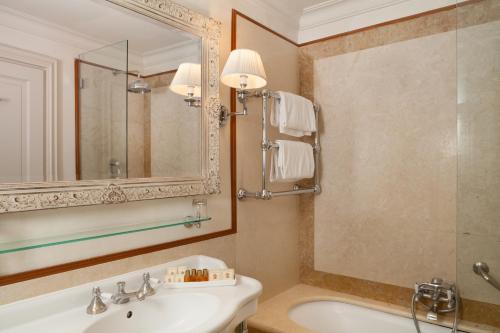 a bathroom with a tub and a sink and a mirror at Hotel Executive in Florence