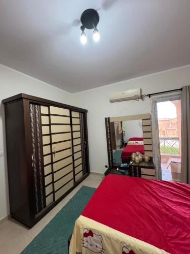 a bedroom with a red bed and a mirror at 3 bedrooms villa in Ain sokhna in Ain Sokhna