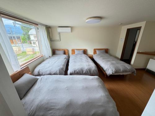 Postel nebo postele na pokoji v ubytování Kurumi House