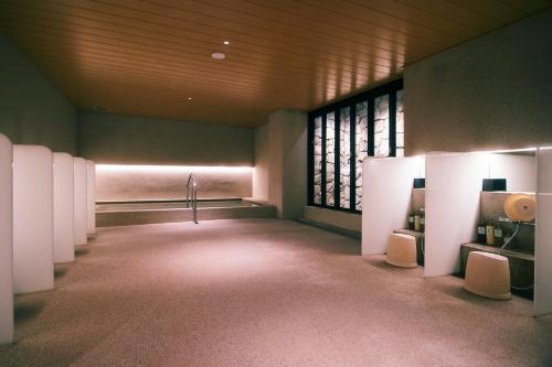 a bathroom with white stalls in a room with windows at hotel androoms Kyoto Shichijo in Kyoto