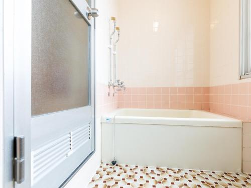 a bathroom with a shower and a tub and a toilet at Tabist JKNツインホテル in Asahikawa