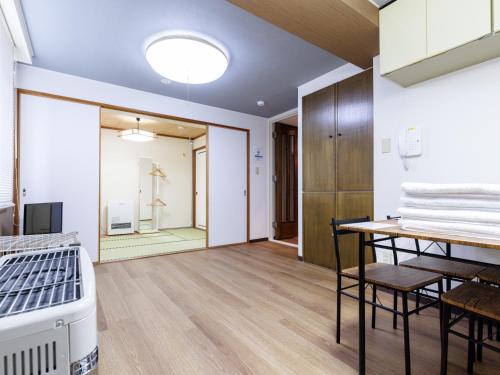 a room with a bed and a table with towels at Tabist JKNツインホテル in Asahikawa