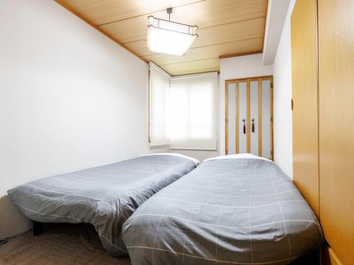 a bed in a room with a window at Tabist JKNツインホテル in Asahikawa