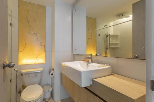 een badkamer met een wastafel, een toilet en een spiegel bij Atlatis condo 2 bedroom in Jomtien Beach