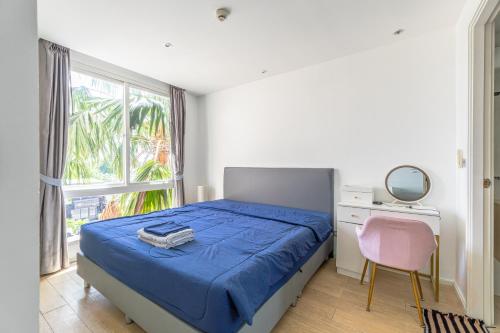 een slaapkamer met een bed, een bureau en een raam bij Atlatis condo 2 bedroom in Jomtien Beach