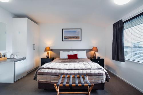 a bedroom with a bed with a red pillow on it at The Halswell in Christchurch