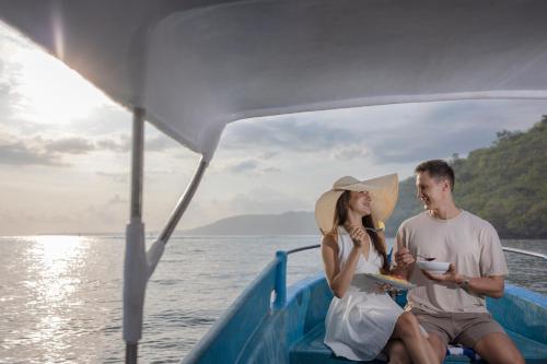 a man and woman on a boat on the water at Pramana Nusa Ceningan in Nusa Lembongan