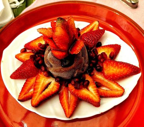 a plate of food with strawberries and beans on a table at Hotel Boutique Casa de Hacienda Su Merced in Puembo