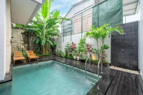 a swimming pool in the middle of a building with plants at Modern 5BR Luxury Villa with Pool & Rooftop - 100m from Sanur Beach in Sanur